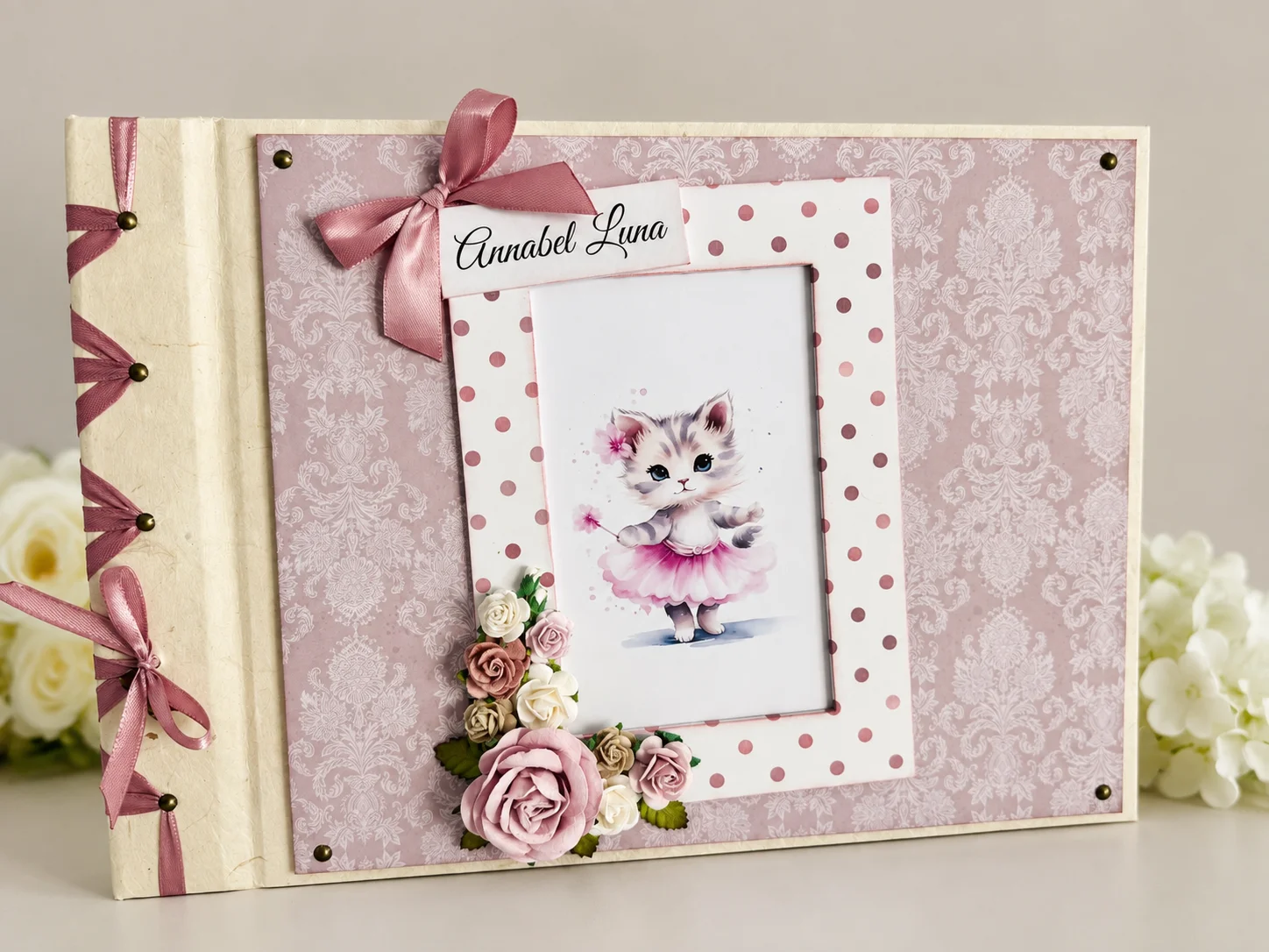 Roosa beebialbum Annabel-Lunale kassipoja ja lilledega